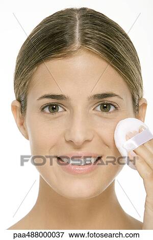Woman using powder puff on cheek, smiling at camera, close-up View Large Photo Image Stock Photo - Woman using powder puff on cheek, smiling at camera, close-up. Fotosearch