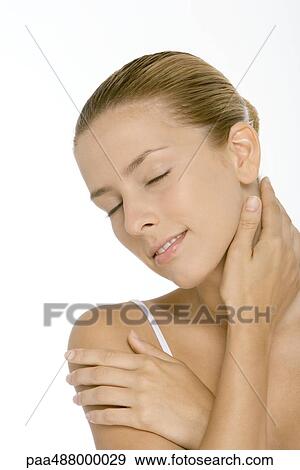 Young woman touching neck and shoulder, smiling, eyes closed View Large Photo Image Stock Photo - Young woman touching neck and shoulder, smiling, eyes closed. Fotosearch