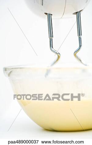 Stock Photo - Electric mixer and bowl of batter, close-up, low angle view. Fotosearch