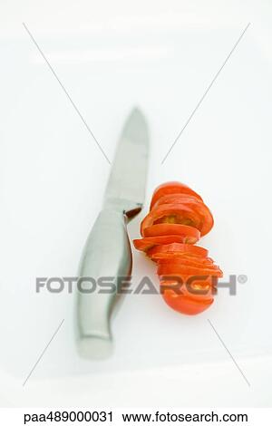 Sliced tomato and knife on cutting board, close-up View Large Photo Image Stock Image - Sliced tomato and knife on cutting board, close-up. Fotosearch