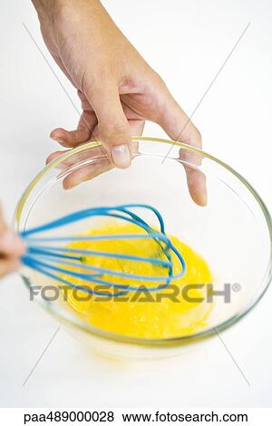 Woman whisking eggs in bowl, cropped, high angle view View Large Photo Image Stock Photo - Woman whisking eggs in bowl, cropped, high angle view. Fotosearch