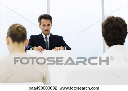 Businessman speaking from lectern, colleagues sitting in foreground View Large Photo Image Stock Image - Businessman speaking from lectern, colleagues sitting in foreground. Fotosearch