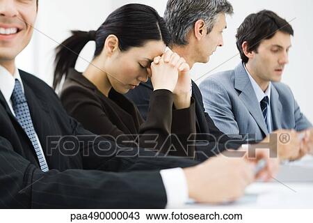 Executives in business meeting, woman closing eyes and leaning head against hands View Large Photo Image Stock Image - Executives in business meeting, woman closing eyes and leaning head against hands. Fotosearch
