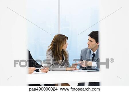 Picture - Male and female business colleagues talking during meeting. Fotosearch