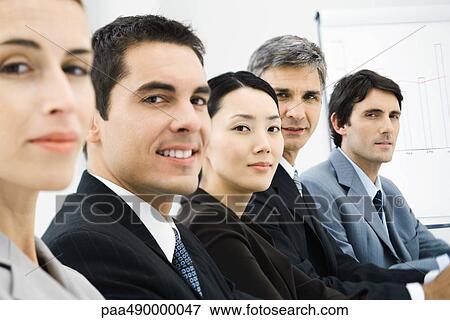 Row of business executives in conference room, smilng at camera View Large Photo Image Stock Photo - Row of business executives in conference room, smilng at camera. Fotosearch