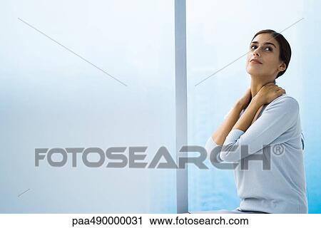 Woman with hands behind neck, looking up View Large Photo Image Stock Image - Woman with hands behind neck, looking up. Fotosearch