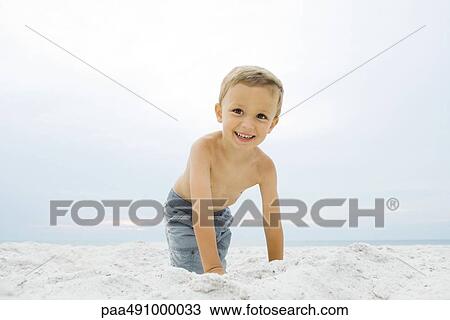 Little boy crouching at the beach, smiling at camera, portrait View Large Photo Image Stock Image - Little boy crouching at the beach, smiling at camera, portrait. Fotosearch