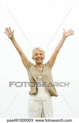 Senior woman standing outdoors with arms raised in the air, smiling at camera View Large Photo Image Stock Image - Senior woman standing outdoors with arms raised in the air, smiling at camera. Fotosearch