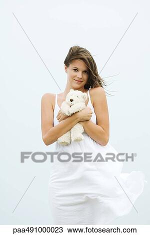 Teenage girl in sundress holding teddy bear, touseled by wind, smiling at camera View Large Photo Image Stock Image - Teenage girl in sundress holding teddy bear, touseled by wind, smiling at camera. Fotosearch