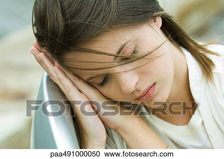 Teenage girl resting head on clasped hands, eyes closed, high angle view View Large Photo Image Stock Image - Teenage girl resting head on clasped hands, eyes closed, high angle view. Fotosearch