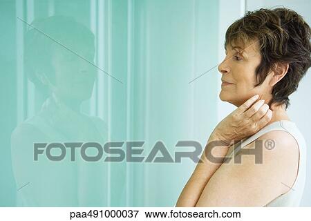 Woman looking at her reflection in window, side view View Large Photo Image Stock Photo - Woman looking at her reflection in window, side view. Fotosearch