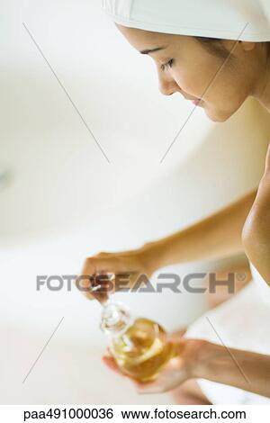 Woman opening perfume bottle, side view, high angle, cropped View Large Photo Image Stock Photograph - Woman opening perfume bottle, side view, high angle, cropped. Fotosearch