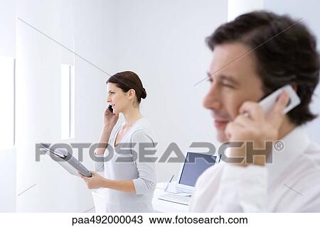 Business people in office using cell phones View Large Photo Image Stock Image - Business people in office using cell phones. Fotosearch