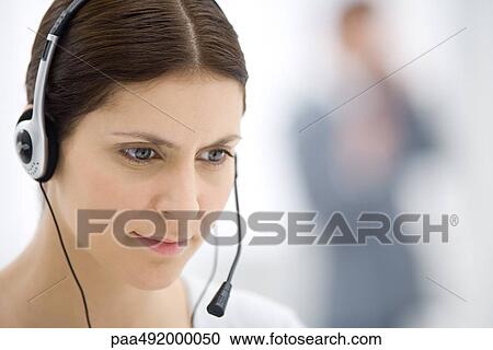 Customer service representative wearing headset, listening and looking down, close-up View Large Photo Image Stock Image - Customer service representative wearing headset, listening and looking down, close-up. Fotosearch