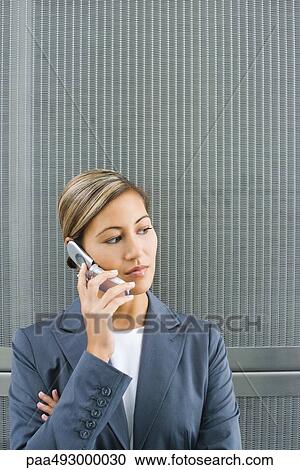 Businesswoman using cell phone, looking away View Large Photo Image Stock Image - Businesswoman using cell phone, looking away. Fotosearch