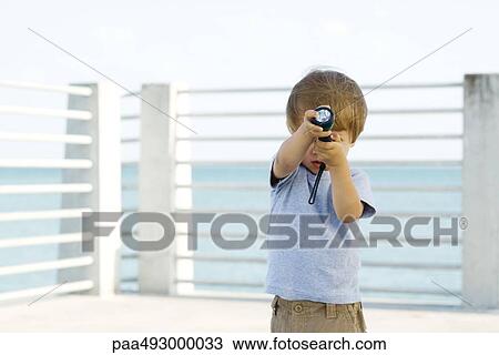 Little boy standing outdoors, holding a flashlight in front of his face View Large Photo Image Stock Image - Little boy standing outdoors, holding a flashlight in front of his face. Fotosearch