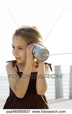 Little girl listening to tin can phone View Large Photo Image Stock Photo - Little girl listening to tin can phone. Fotosearch
