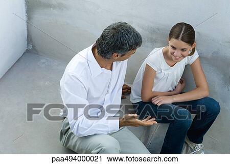 Father and daughter sitting together, chatting, high angle view View Large Photo Image Stock Image - Father and daughter sitting together, chatting, high angle view. Fotosearch
