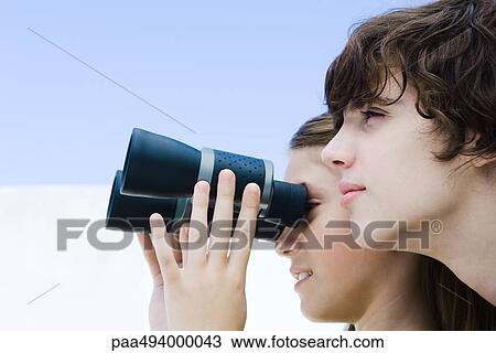 Preteen girl looking away through binoculars, brother nearby, profile View Large Photo Image Stock Image - Preteen girl looking away through binoculars, brother nearby, profile. Fotosearch