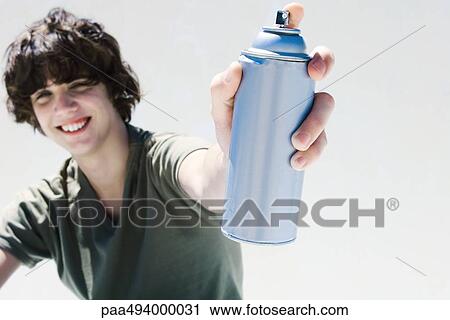 Teenage boy holding can of spray paint, smiling at camera View Large Photo Image Stock Image - Teenage boy holding can of spray paint, smiling at camera. Fotosearch
