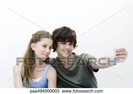 Teenage boy photographing himself and sister with camera phone View Large Photo Image Stock Image - Teenage boy photographing himself and sister with camera phone. Fotosearch