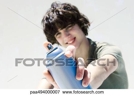 Teenage boy pointing can of spray paint at camera, focus on the foreground View Large Photo Image Stock Photo - Teenage boy pointing can of spray paint at camera, focus on the foreground. Fotosearch