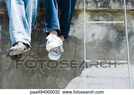 Two people sitting beside ladder, legs crossed at ankle, cropped view View Large Photo Image Stock Image - Two people sitting beside ladder, legs crossed at ankle, cropped view. Fotosearch