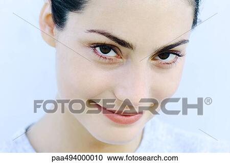 Stock Image - Woman smiling at camera, headshot, portrait. Fotosearch
