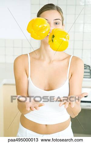 Woman juggling yellow bell peppers in kitchen View Large Photo Image Stock Image - Woman juggling yellow bell peppers in kitchen. Fotosearch