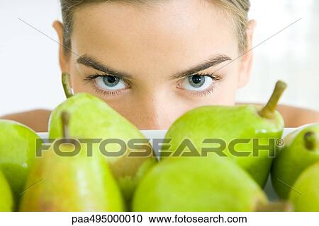Young woman looking over tray of pears View Large Photo Image Stock Image - Young woman looking over tray of pears. Fotosearch