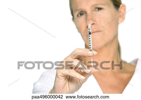 Woman holding up syringe, looking at camera View Large Photo Image Stock Image - Woman holding up syringe, looking at camera. Fotosearch