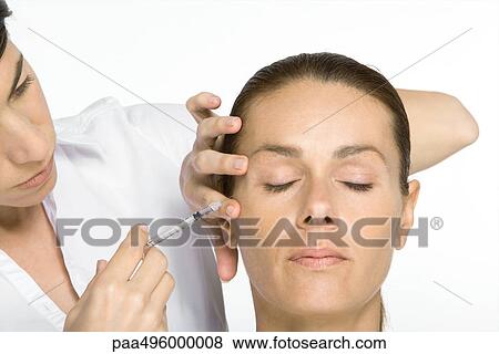 Stock Photo - Woman receiving Botox injection, eyes closed. Fotosearch