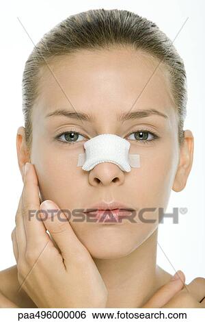 Stock Photograph - Woman with bandaged nose, looking at camera, portrait. Fotosearch