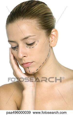 Woman with plastic surgery markings on face, hand under chin, looking down View Large Photo Image Stock Photo - Woman with plastic surgery markings on face, hand under chin, looking down. Fotosearch