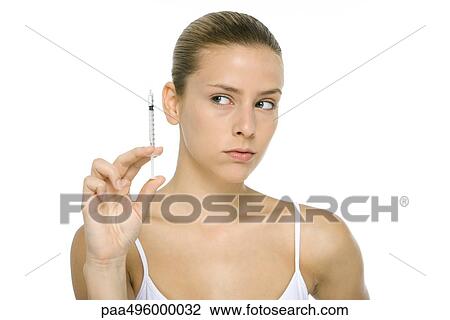 Young woman looking at syringe, close-up View Large Photo Image Stock Image - Young woman looking at syringe, close-up. Fotosearch