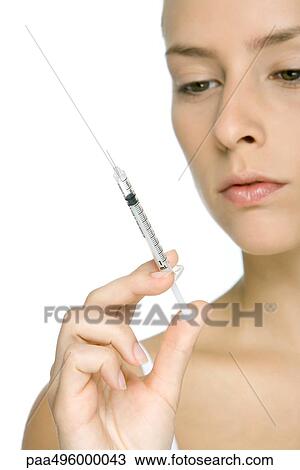 Young woman looking at syringe, cropped view View Large Photo Image Stock Image - Young woman looking at syringe, cropped view. Fotosearch