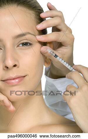 Stock Photograph - Young woman receiving Botox injection, cropped view. Fotosearch
