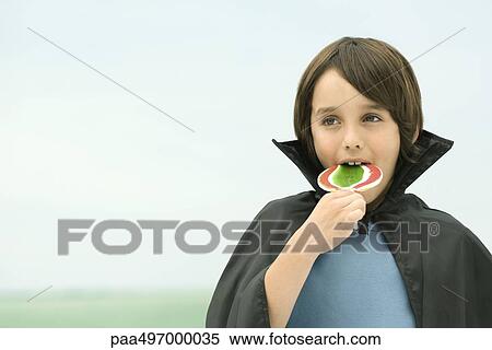 Boy wearing vampire cape, eating large lollipop, portrait View Large Photo Image Stock Photography - Boy wearing vampire cape, eating large lollipop, portrait. Fotosearch