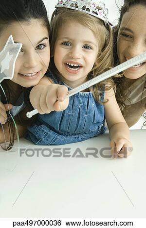 Girl dressed as princess, holding wand, surrounded by sister and mother View Large Photo Image Stock Photograph - Girl dressed as princess, holding wand, surrounded by sister and mother. Fotosearch