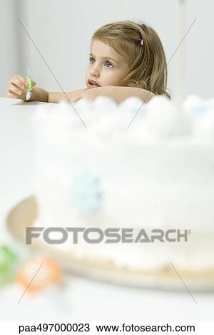 Little girl holding candy, birthday cake in foreground View Large Photo Image Stock Image - Little girl holding candy, birthday cake in foreground. Fotosearch