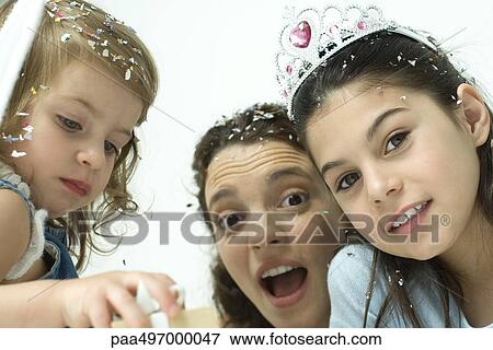 Mother and two daughters celebrating with confetti View Large Photo Image Stock Photo - Mother and two daughters celebrating with confetti. Fotosearch