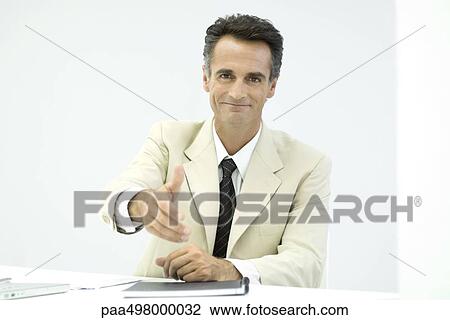 Businessman offering his hand to camera, smiling View Large Photo Image Stock Image - Businessman offering his hand to camera, smiling. Fotosearch
