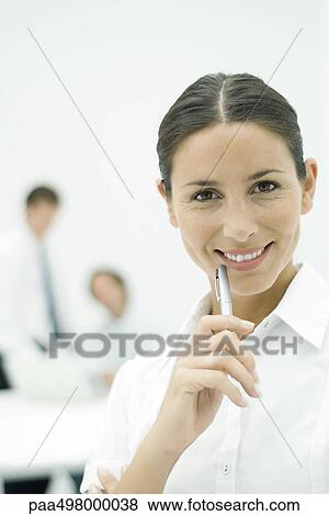 Female professional smiling at camera, holding pen up to chin, portrait View Large Photo Image Stock Photo - Female professional smiling at camera, holding pen up to chin, portrait. Fotosearch
