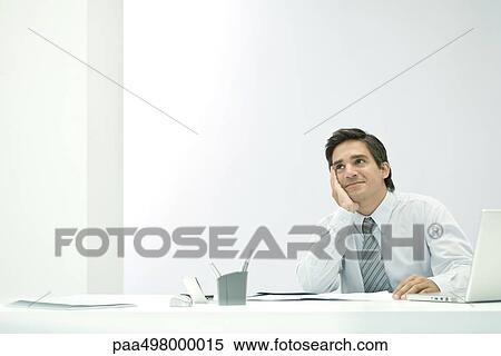Male professional daydreaming at desk, hand under chin View Large Photo Image Stock Photography - Male professional daydreaming at desk, hand under chin. Fotosearch