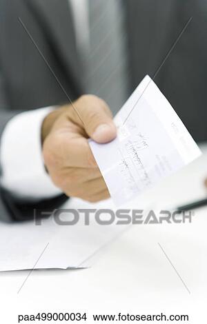 Businessman holding out check, cropped view of hand View Large Photo Image Picture - Businessman holding out check, cropped view of hand. Fotosearch