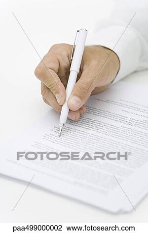 Businessman reviewing contract with pen, cropped view of hand View Large Photo Image Stock Image - Businessman reviewing contract with pen, cropped view of hand. Fotosearch