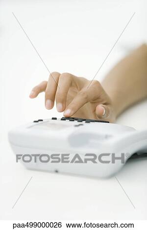 Stock Photograph - Hand dialing landline phone, cropped view. Fotosearch