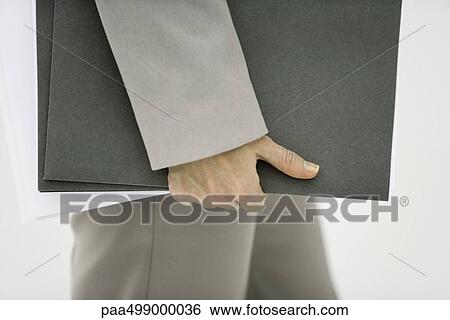 Stock Photograph - Man carrying folders, side view, cropped. Fotosearch