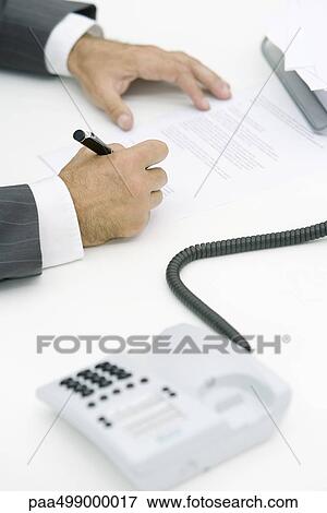 Man signing document, cropped view, landline phone off the hook in foreground View Large Photo Image Stock Photo - Man signing document, cropped view, landline phone off the hook in foreground. Fotosearch