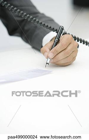 Man using phone and signing check, cropped view of hand View Large Photo Image Picture - Man using phone and signing check, cropped view of hand. Fotosearch